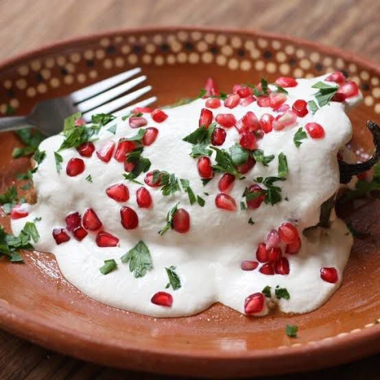 Para preparar el tradicional chile en nogada mexicano, necesitas chiles poblanos, picadillo de carne con frutas y salsa de nuez de castilla.